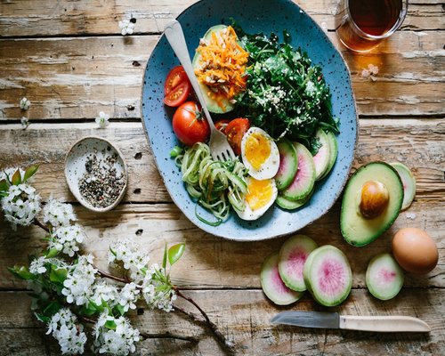 Fresh green salad with hard boiled egg and sliced avocado